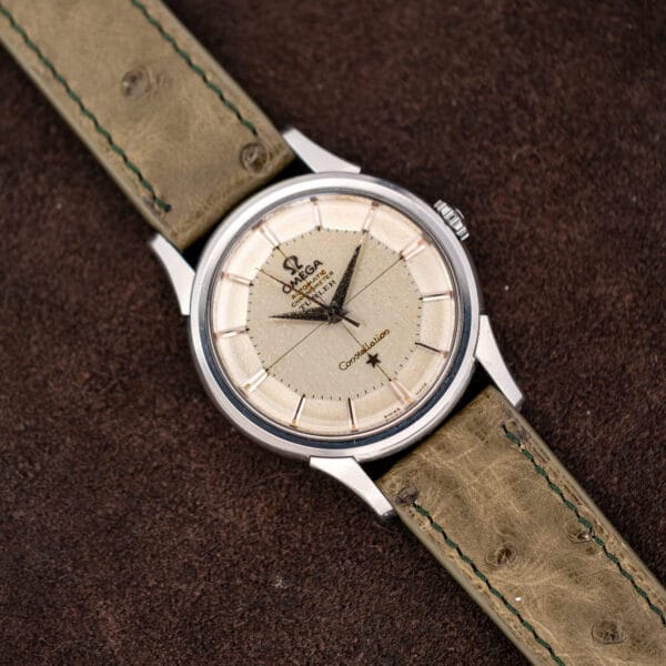 Omega Constellation 14381-7 angled view, faceted pie-pan dial above an olive ostrich strap with green stitching