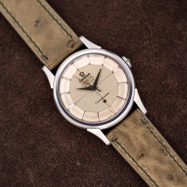 Omega Constellation 14381-7 angled view, faceted pie-pan dial above an olive ostrich strap with green stitching