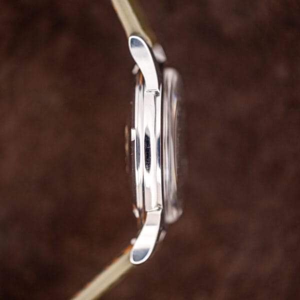 Slim stainless Omega Constellation case in profile, faceted lugs and acrylic crystal standing proud of the bezel