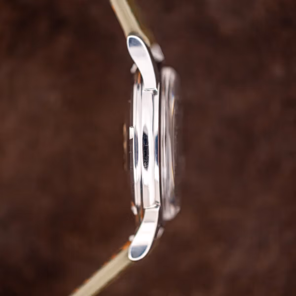 Slim stainless Omega Constellation case in profile, faceted lugs and acrylic crystal standing proud of the bezel