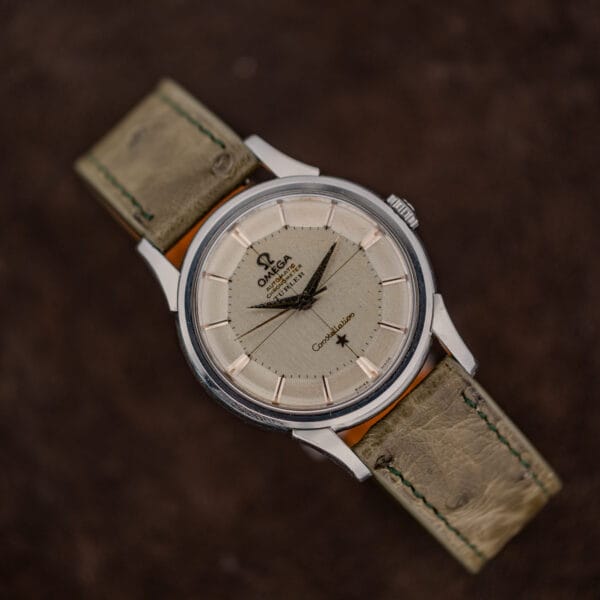 Omega Constellation 14381 pie-pan dial in even aged tone with scattered dark specks, on a worn olive strap