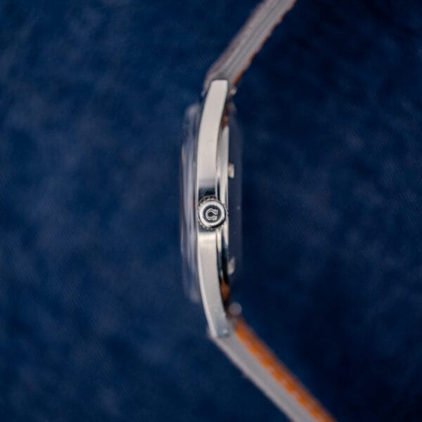Omega Geneve 166.041 side profile with domed acrylic crystal standing proud of the fixed steel bezel