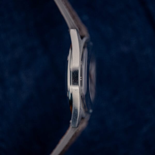 Omega 166.041 mid-case flank in stainless steel with light surface hairlines from decades of wear