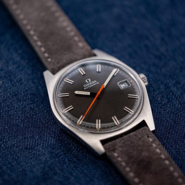Vintage Omega Geneve automatic 166.041 front view with white-stitched suede strap and orange central seconds hand