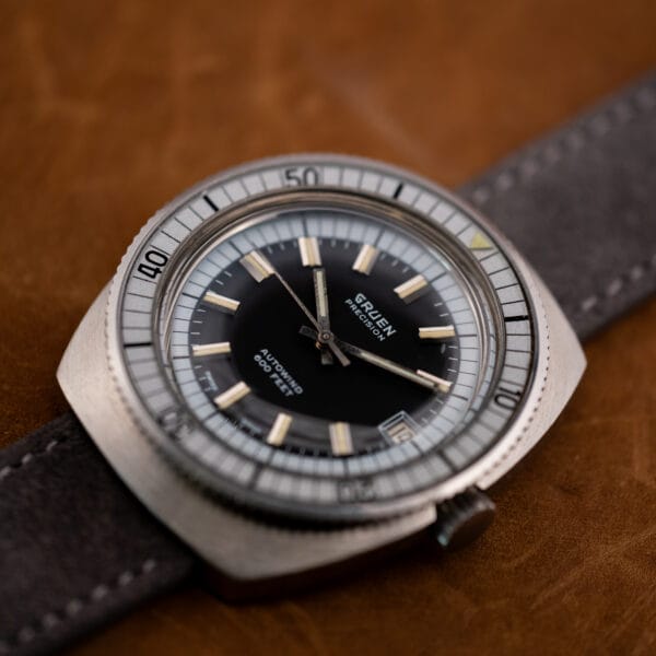 Gruen Precision Autowind angled dial view with silver-grey bakelite bezel insert and lume triangle at the zero marker