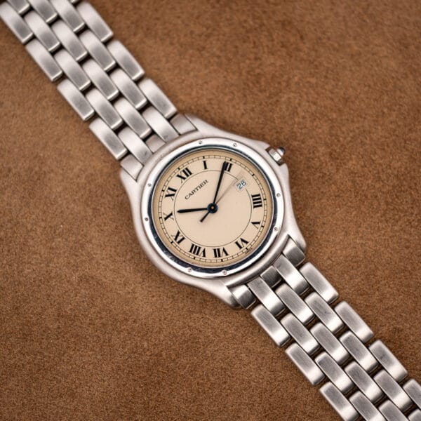 Cartier Cougar 987904 on brown suede, blue cabochon crown and polished steel bezel ring visible
