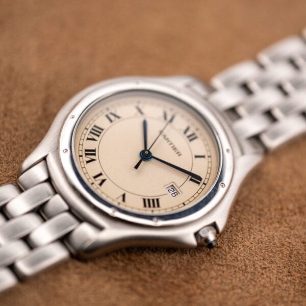 Angled macro of the Cartier Cougar eggshell dial, blued hands and date window at three