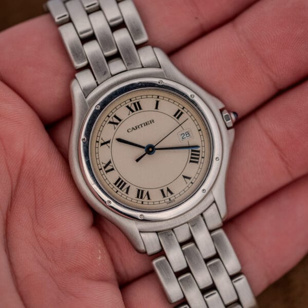 Light hairlines across the polished bezel ring and steel bracelet of the Cartier Cougar 987904
