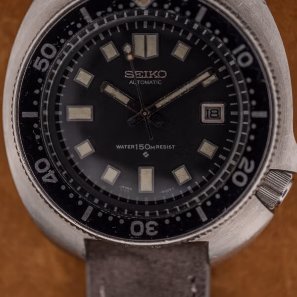 Black 6105-8119 dial with date at three, aged cream lume plots and bidirectional dive bezel numerals