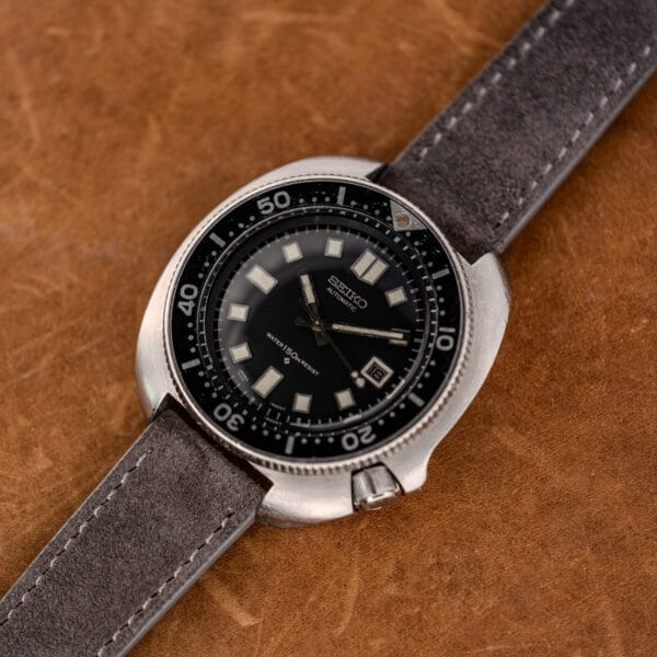 Angled view of the Seiko 6105-8119 cushion case, recessed crown at four and worn black bezel