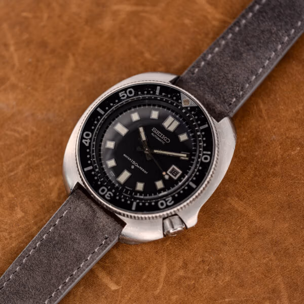 Angled view of the Seiko 6105-8119 cushion case, recessed crown at four and worn black bezel