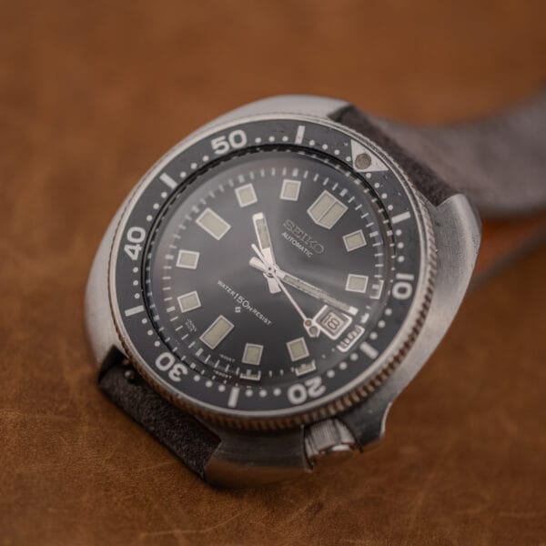 Close angle on the 6105-8119 bezel and crystal, scuff across the center and darkened lume pip