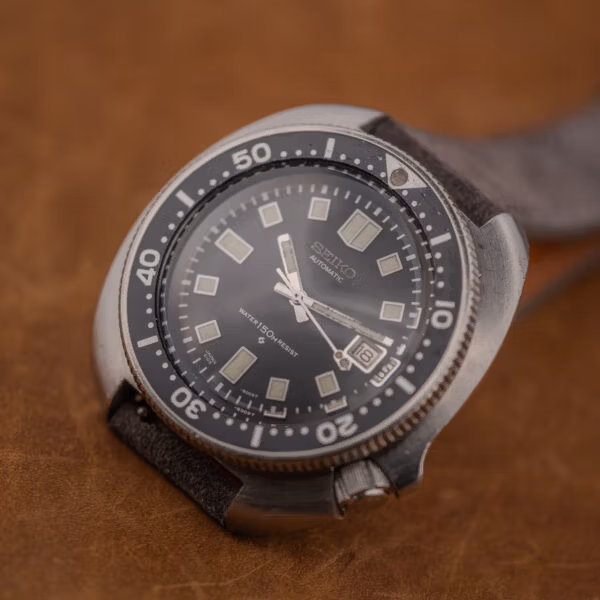 Close angle on the 6105-8119 bezel and crystal, scuff across the center and darkened lume pip