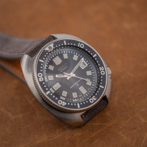 Seiko 6105-8119 dial at an angle, date wheel showing nine, cream lume plots and worn bezel numerals