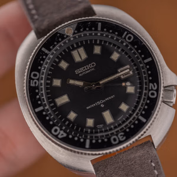 Macro of the Seiko 6105 dial upper half, SEIKO AUTOMATIC printing and evenly aged cream lume markers