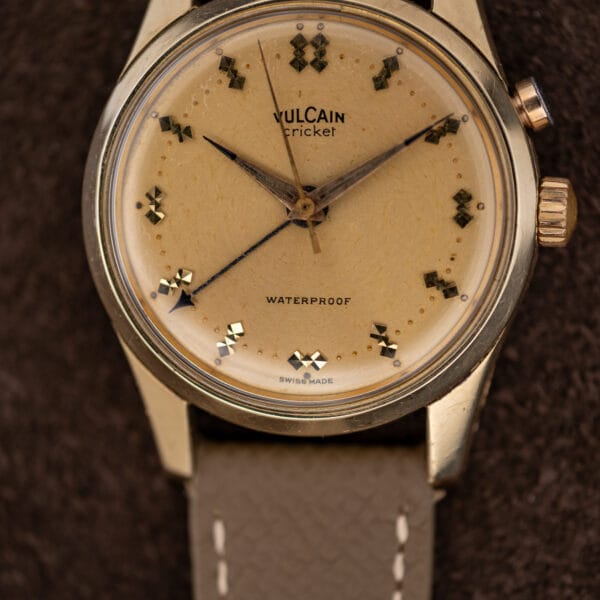 Macro of Vulcain Cricket 307004 dial showing surface crazing, with alarm pusher and winding crown at right