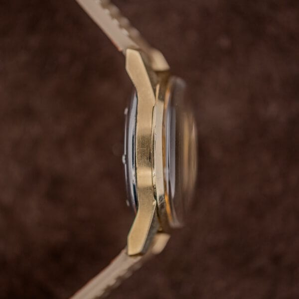 Side profile of the Vulcain Cricket gold capped case, layered case edge, domed crystal, strap fitted