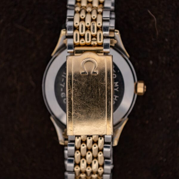 Gold tone Omega signed clasp on two-tone expansion bracelet, scratched from decades of wear