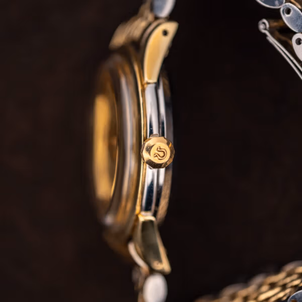 Side profile of Omega Constellation 2852 showing gold capped case flank, faceted lugs and logoed crown