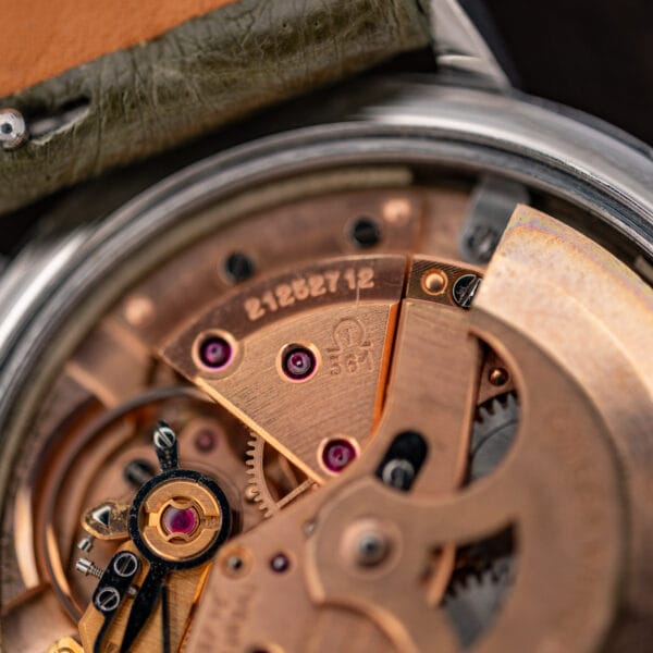 Omega caliber 561 movement close-up showing the numbered bridge, Omega emblem, jewels and adjacent winding rotor