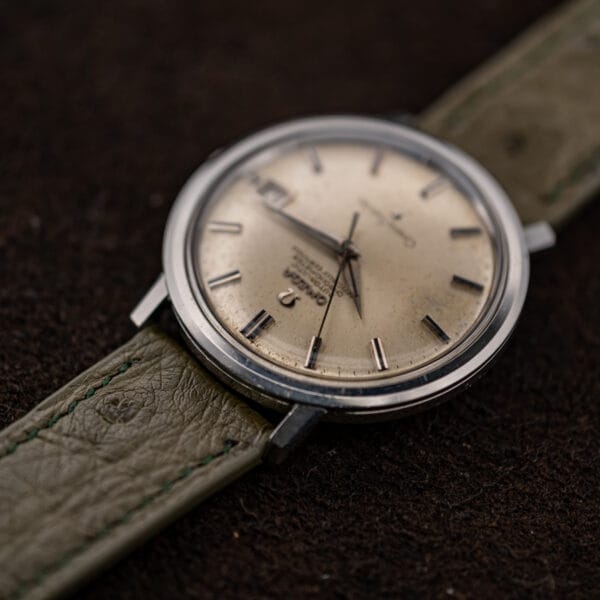 Omega Constellation 168.004 viewed from the twelve end, with applied markers and stitched strap in focus
