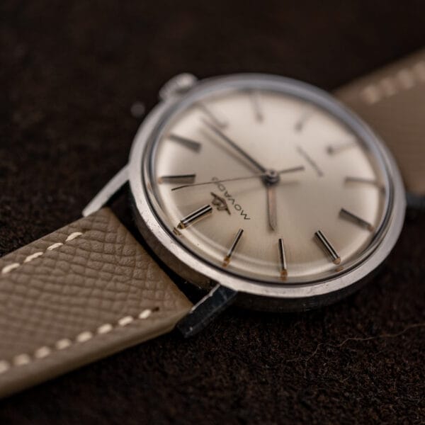 Movado Kingmatic 15161 from the upper lug end, emphasizing the raised crystal and textured taupe leather