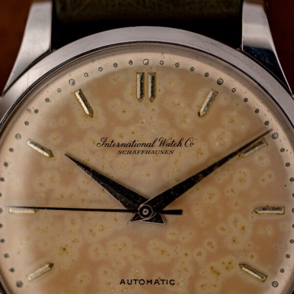 IWC dial close-up showing International Watch Co signature, paired twelve o'clock markers and pointed hands