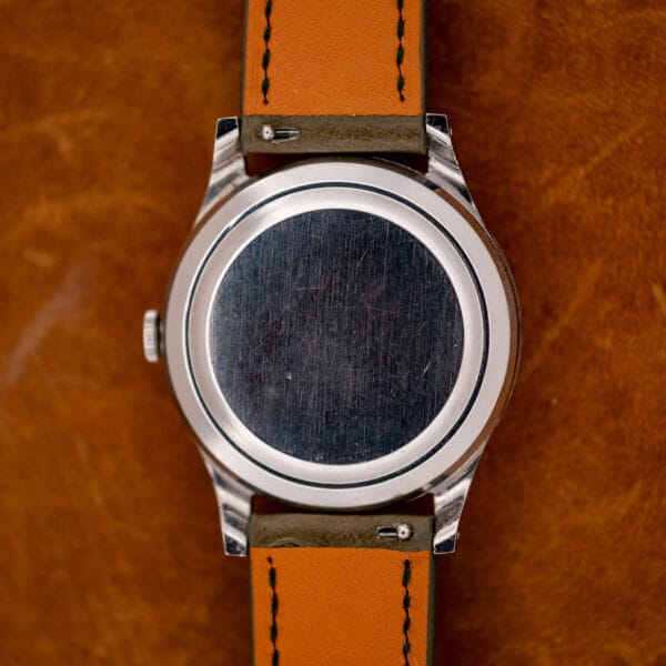 IWC closed caseback with circular brushed center, orange strap lining and visible quick-release spring bar tabs