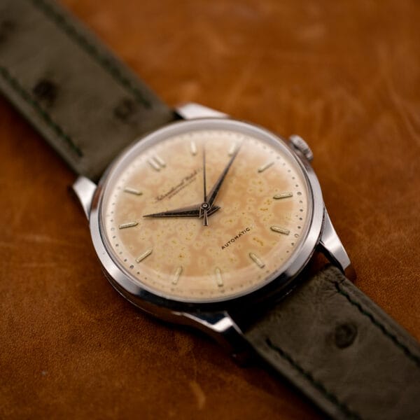 IWC automatic viewed from the lower lugs, with pointed hands and central seconds over the patina dial