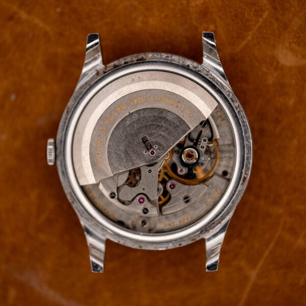 Open IWC automatic case showing the signed semicircular rotor, balance assembly and exposed movement bridges