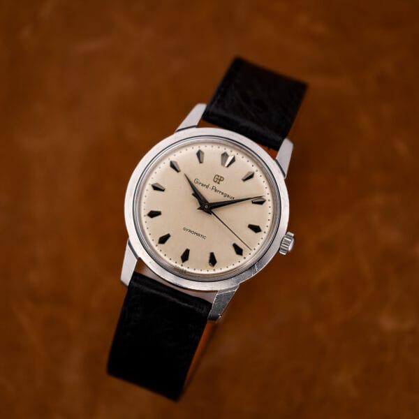 Front view of Girard Perregaux Gyromatic on display stand with black strap