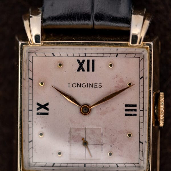 Longines rose dial close-up showing Roman hour numerals, applied dots and square subsidiary seconds