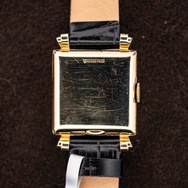 Longines square exterior caseback with gold filled marking and visible black leather strap underside