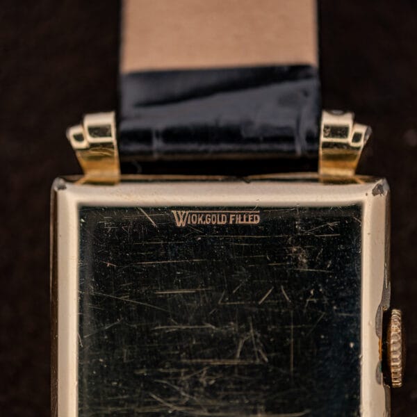 Close-up of Longines exterior back stamped 10K gold filled beside a stylized W emblem