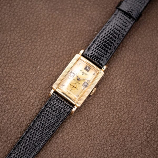 Full-length view of Gruen Precision 335/756 with its black lizard strap extended diagonally across brown fabric