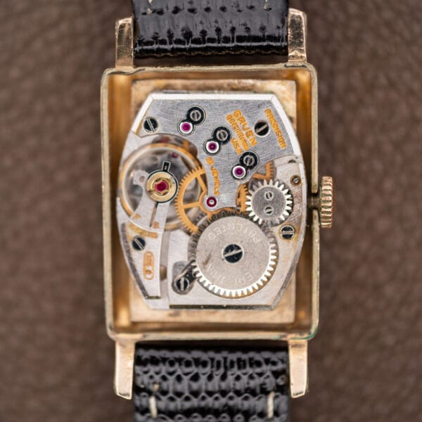 Open Gruen Precision 335/756 case revealing the shaped manual-wind movement, winding wheels and visible balance assembly