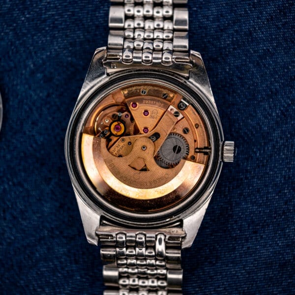 Open Omega Seamaster 168.024 revealing its automatic movement, copper-toned rotor, jeweled bridges and attached bracelet