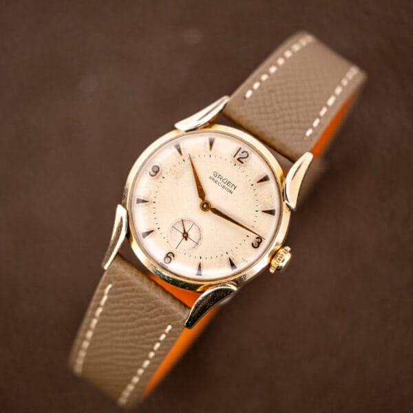 Gruen Precision 415/932 displayed with its strap curved behind the case and all four fancy lugs visible