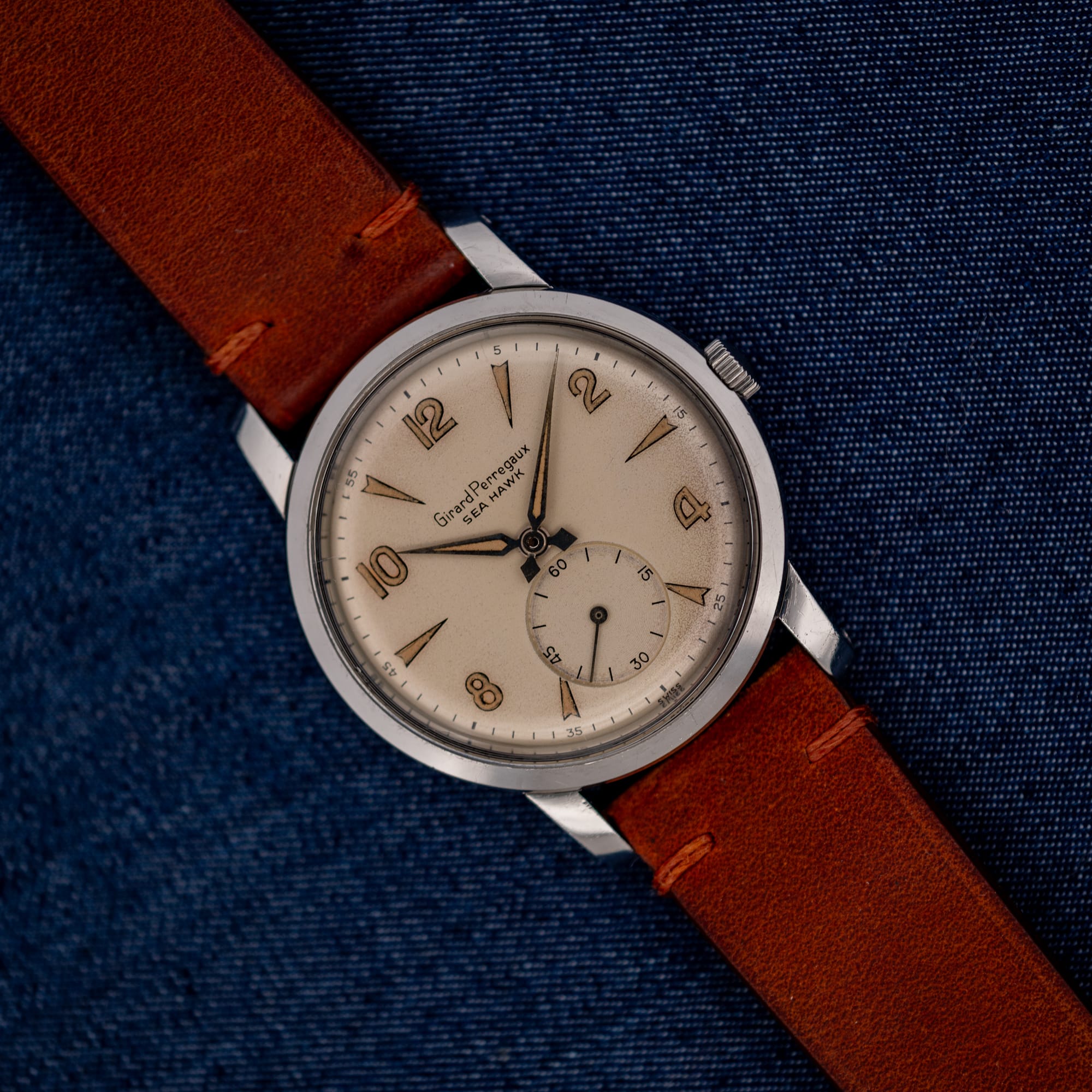DSCF7214 Girard Perregaux Sea Hawk with eggshell dial and brown leather strap resting diagonally on blue fabric