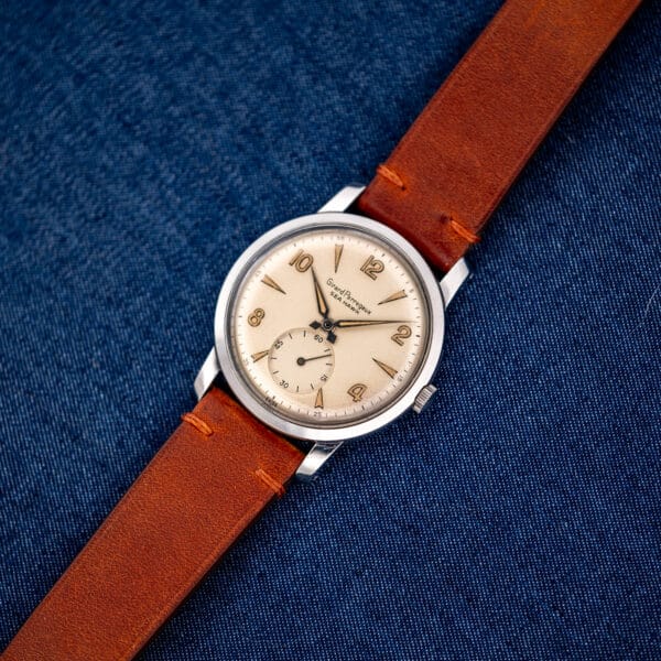 Girard Perregaux Sea Hawk shown face-up with its brown leather strap extended across blue cloth