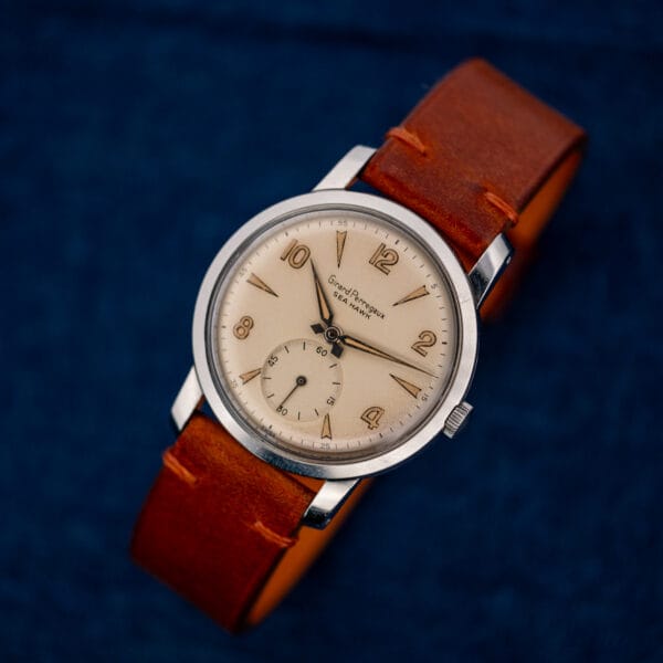Girard Perregaux Sea Hawk resting at an angle with its brown leather strap curved behind the case