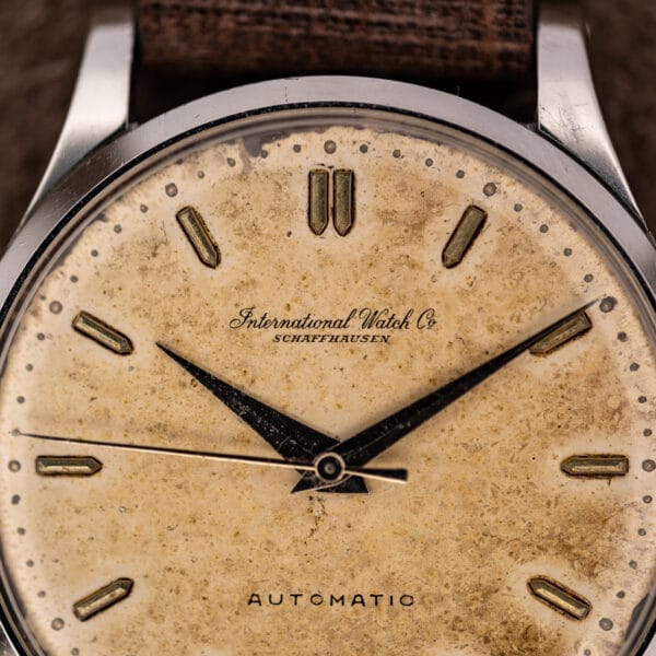 IWC dial close-up showing International Watch Company signature and paired twelve oclock markers