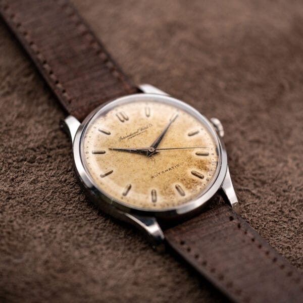 Angled IWC automatic face showing applied baton markers and pronounced dial patina