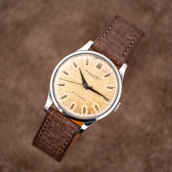 IWC automatic on display stand showing mottled dial and textured brown Babele strap