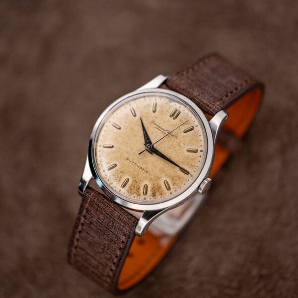 Three-quarter IWC automatic view showing ridged crown, curved lugs and strap loop
