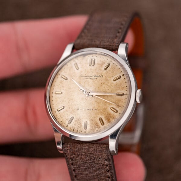 Hand-held IWC automatic at a low angle with brightly reflecting dauphine hands