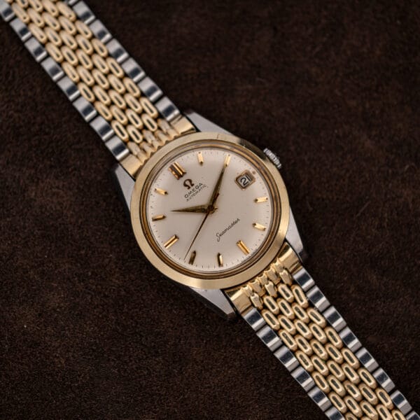 Overhead view of Omega Seamaster 14744-1 with smooth gold bezel, steel lugs and extended bracelet