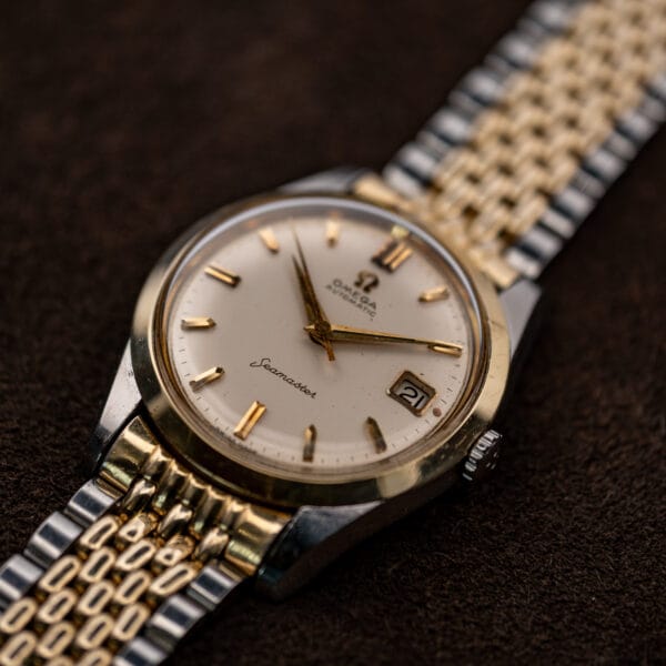 Angled Omega Seamaster 14744-1 showing the raised crystal, crown and gold-colored central bracelet links