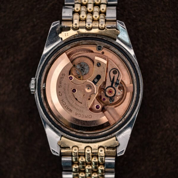 Omega Seamaster 14744-1 with caseback removed, exposing the signed automatic winding rotor and movement
