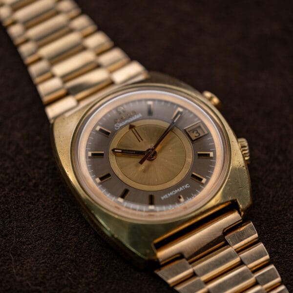 Low front view of Omega Memomatic 166.072 showing the lower cushion-case edge and bracelet connection